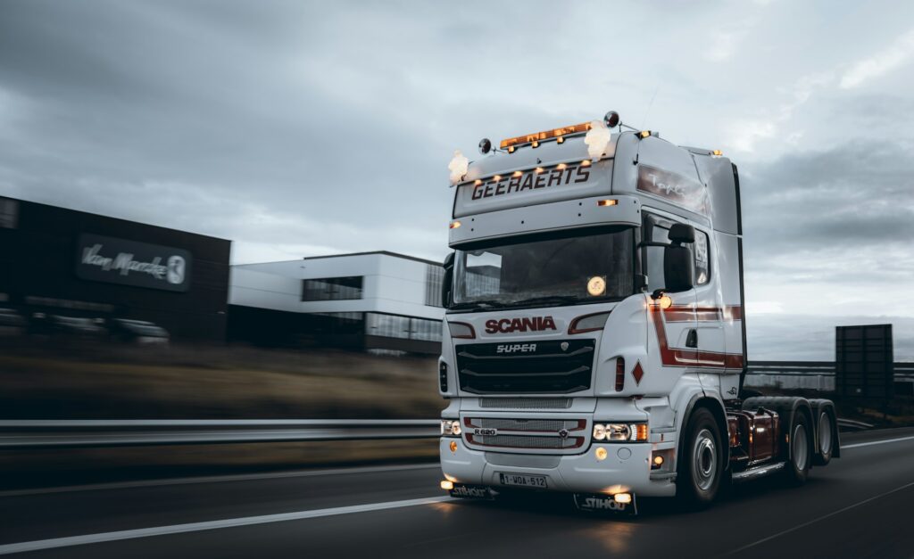 Witte Scania vrachtwagen zonder oplegger rijdt over snelweg, perfect voorbeeld voor vrachtwagenrijbewijs praktijkles