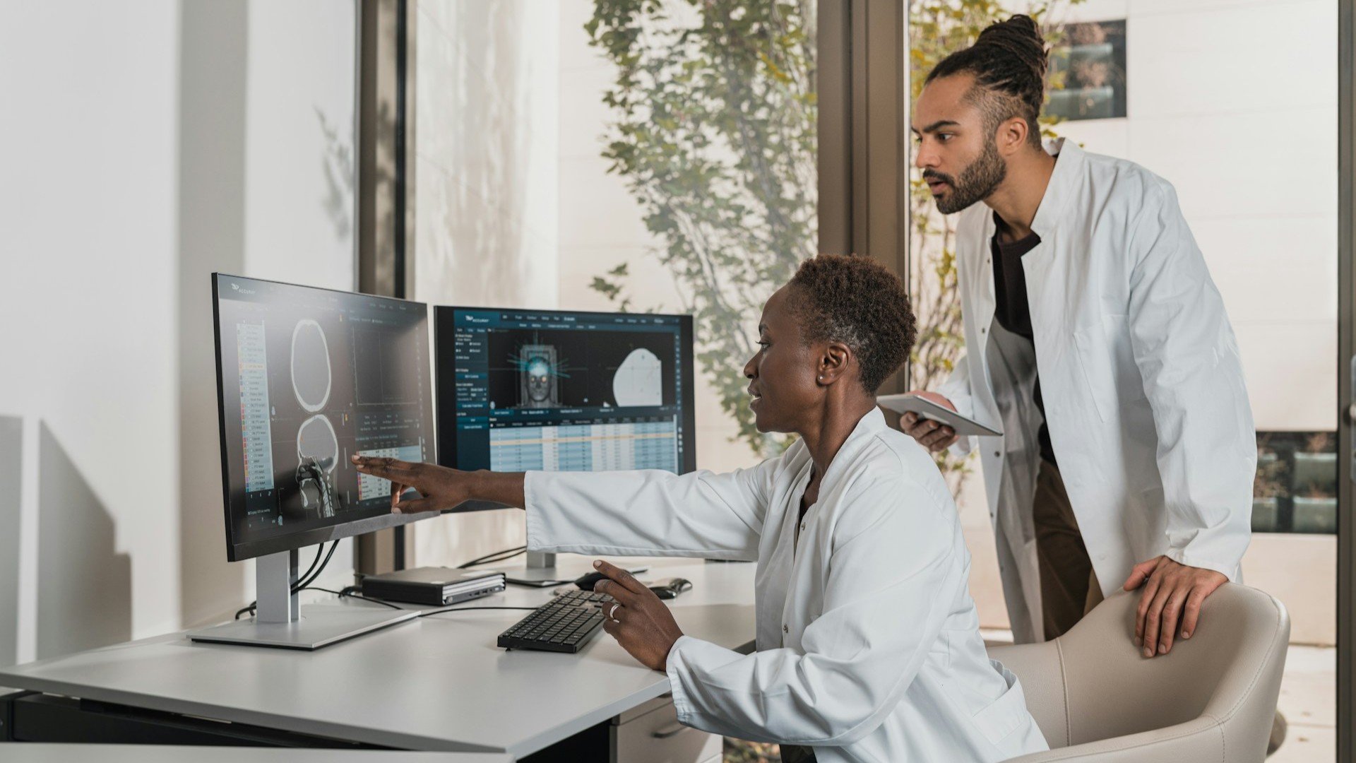 Artsen analyseren scans op beeldschermen om de hoge kans op herstel bij een pati&euml;nt te onderbouwen.