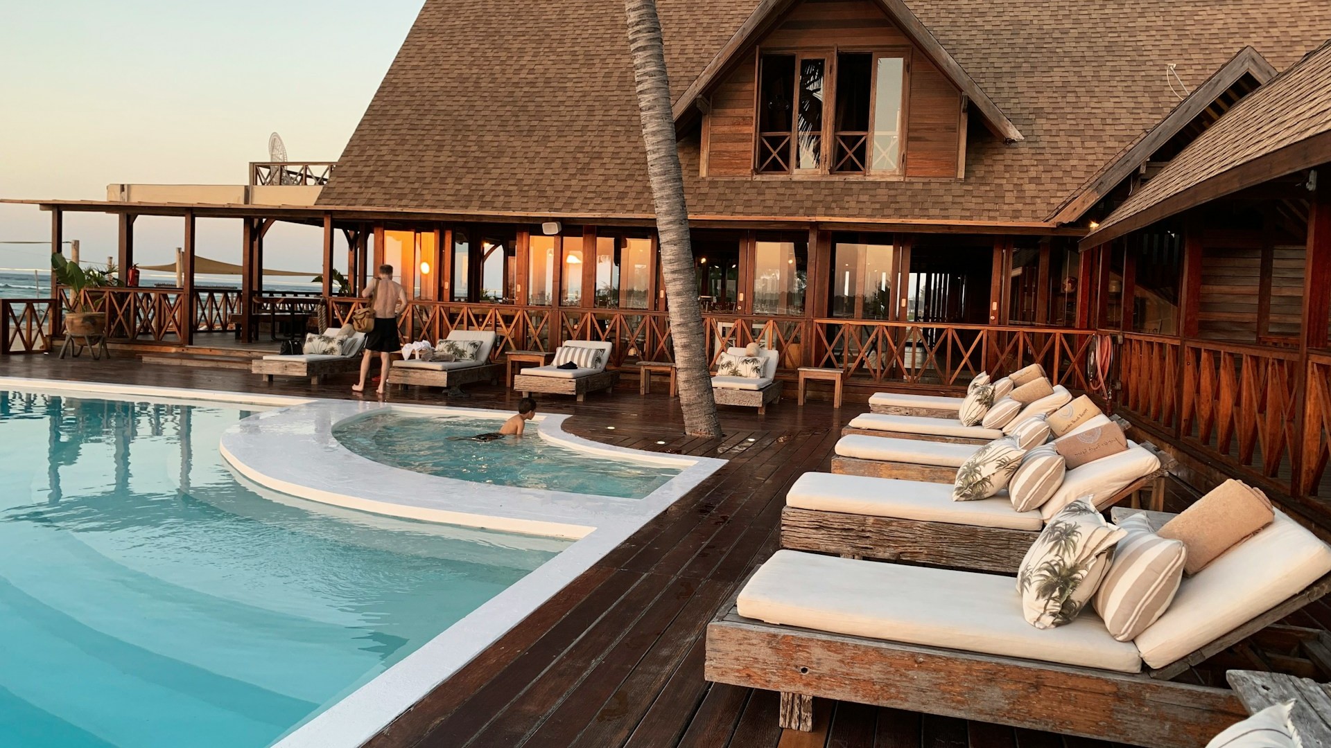 Hotelterras met zwembad, ligstoelen en houten constructie, waarvoor een omgevingsvergunning nodig kan zijn.