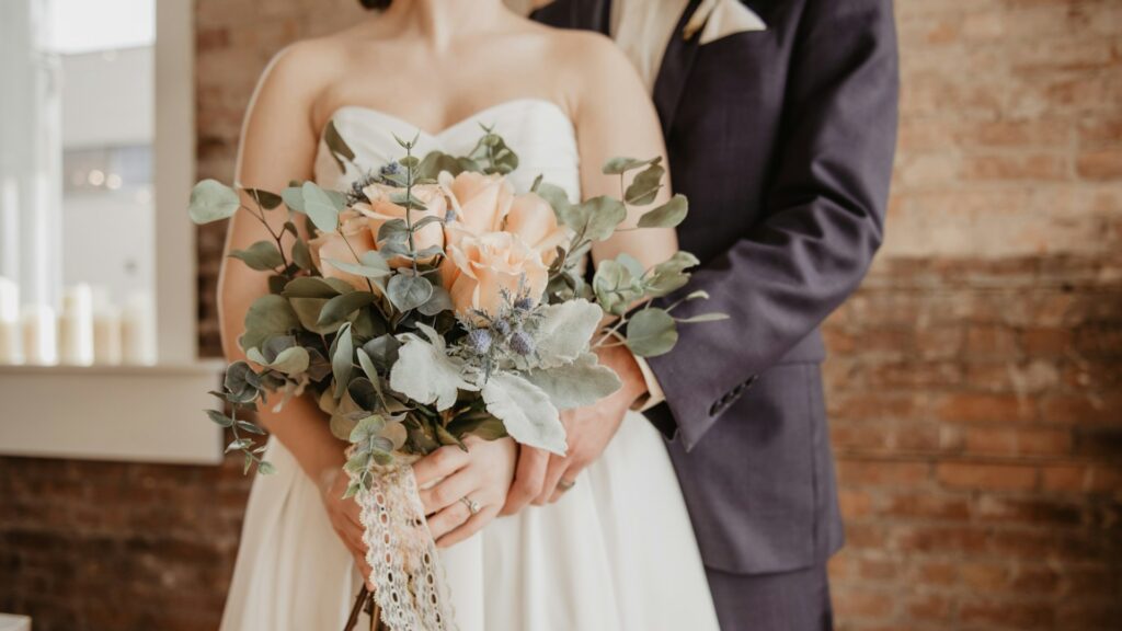 Bruidspaar met boeket tijdens ceremonie, inspiratie voor zwarte kleding bruiloft styling