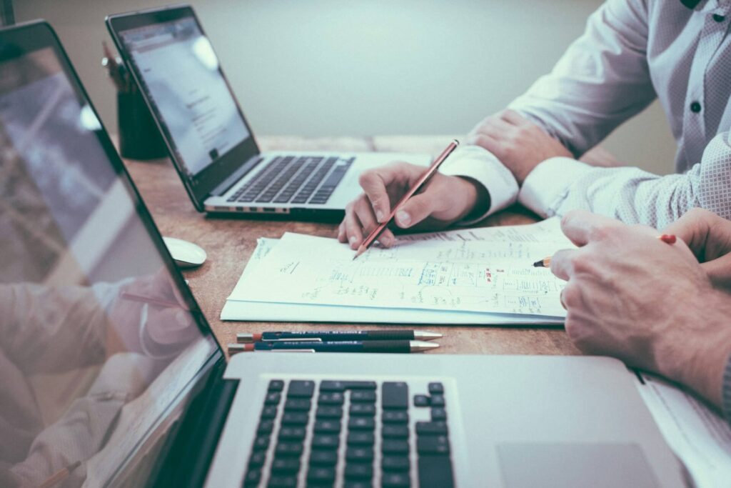 Overleg tussen collega's over budgetten en financiële beslissingen aan een vergadertafel.