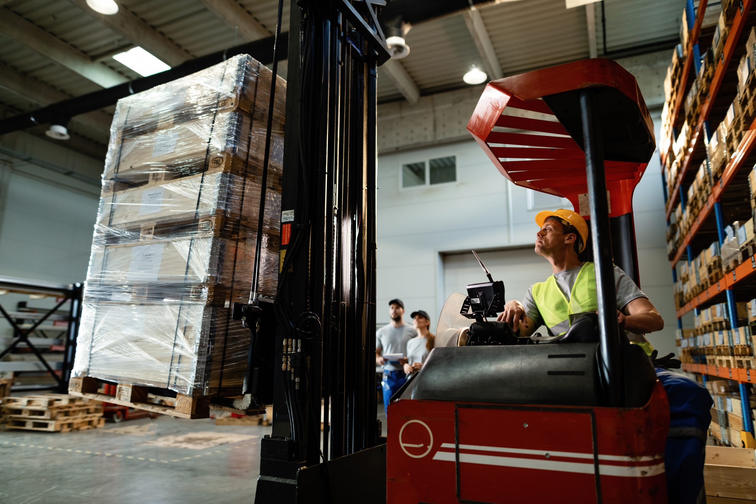 Man werkt op heftruck in magazijn